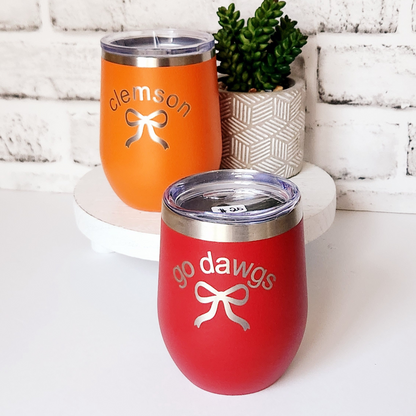 Orange and red tumblers with 'Clemson' and 'Go Dawgs' text on a white surface.