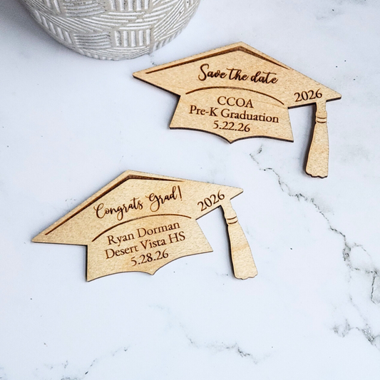 Two wooden graduation cap-shaped save the date magnets with personalized text 