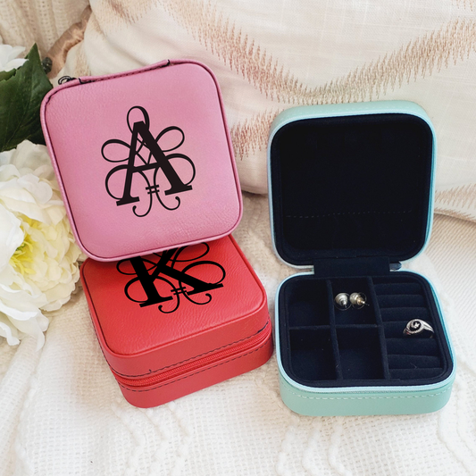 Three jewelry boxes with monograms on a soft fabric background