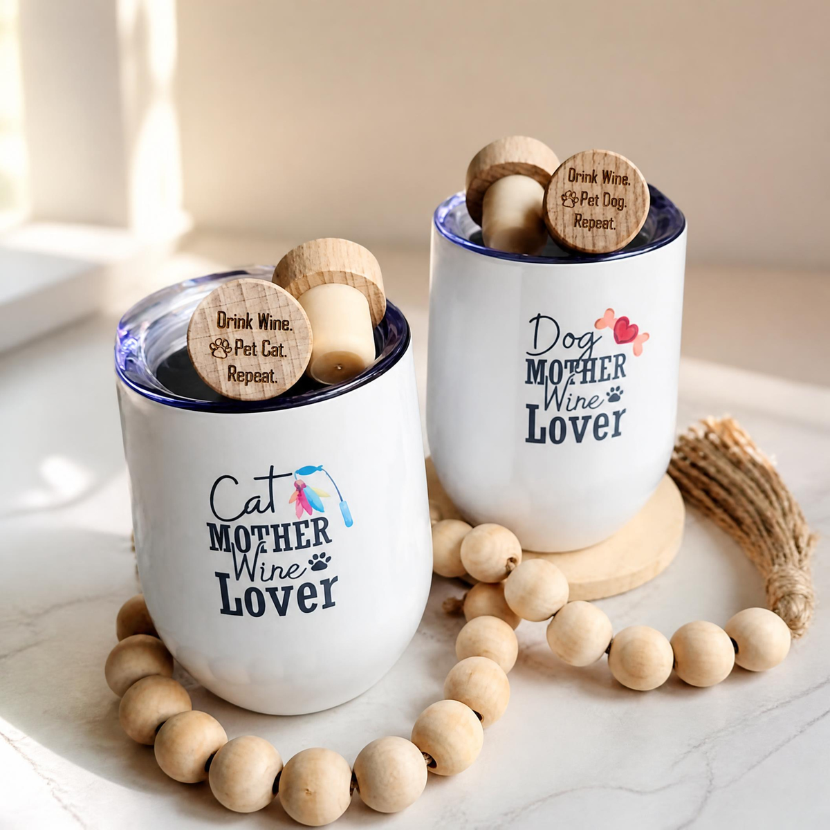 Two white ceramic wine tumblers with clear lids, each holding a wooden stopper engraved with 'Drink Wine. Pet Dog. Repeat' and 'Drink Wine. Pet Cat. Repeat' text. The tumblers are printed with 'Cat Mother Wine Lover' and 'Dog Mother Wine Lover' designs.