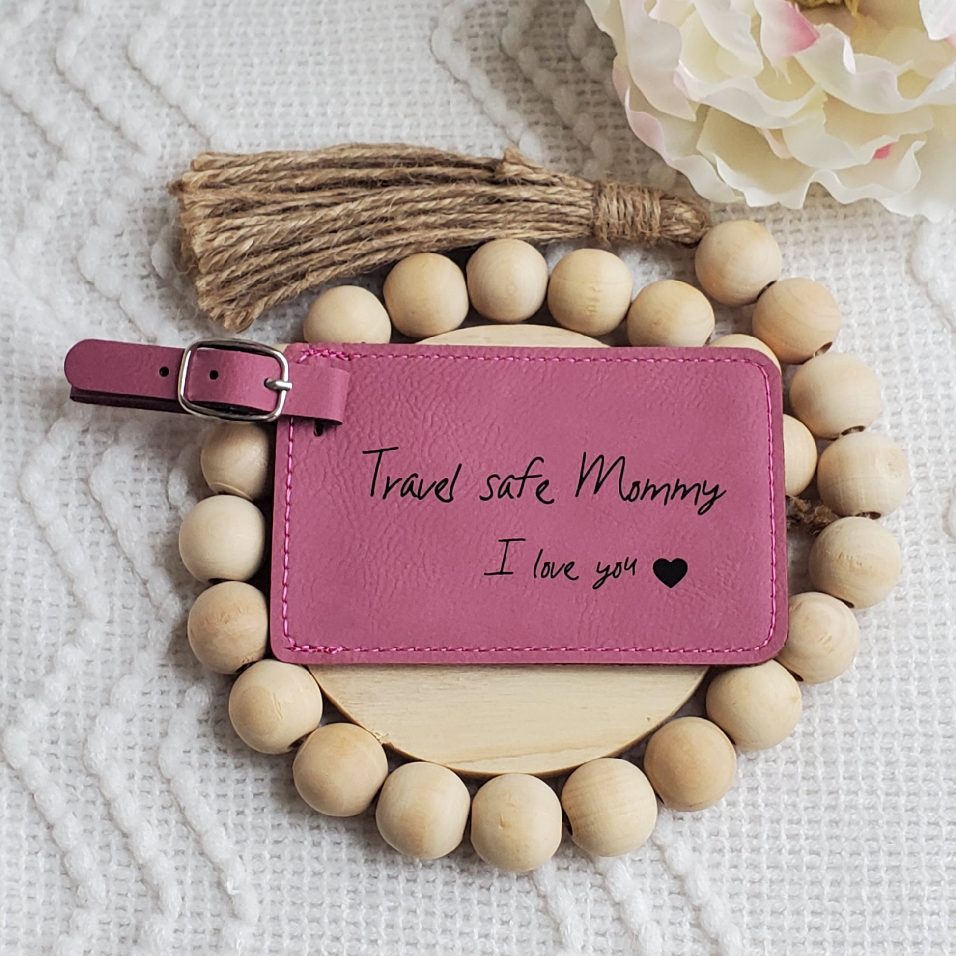Pink luggage Tag with the words Travel safe Mommy I love you and a heart engraved in black.