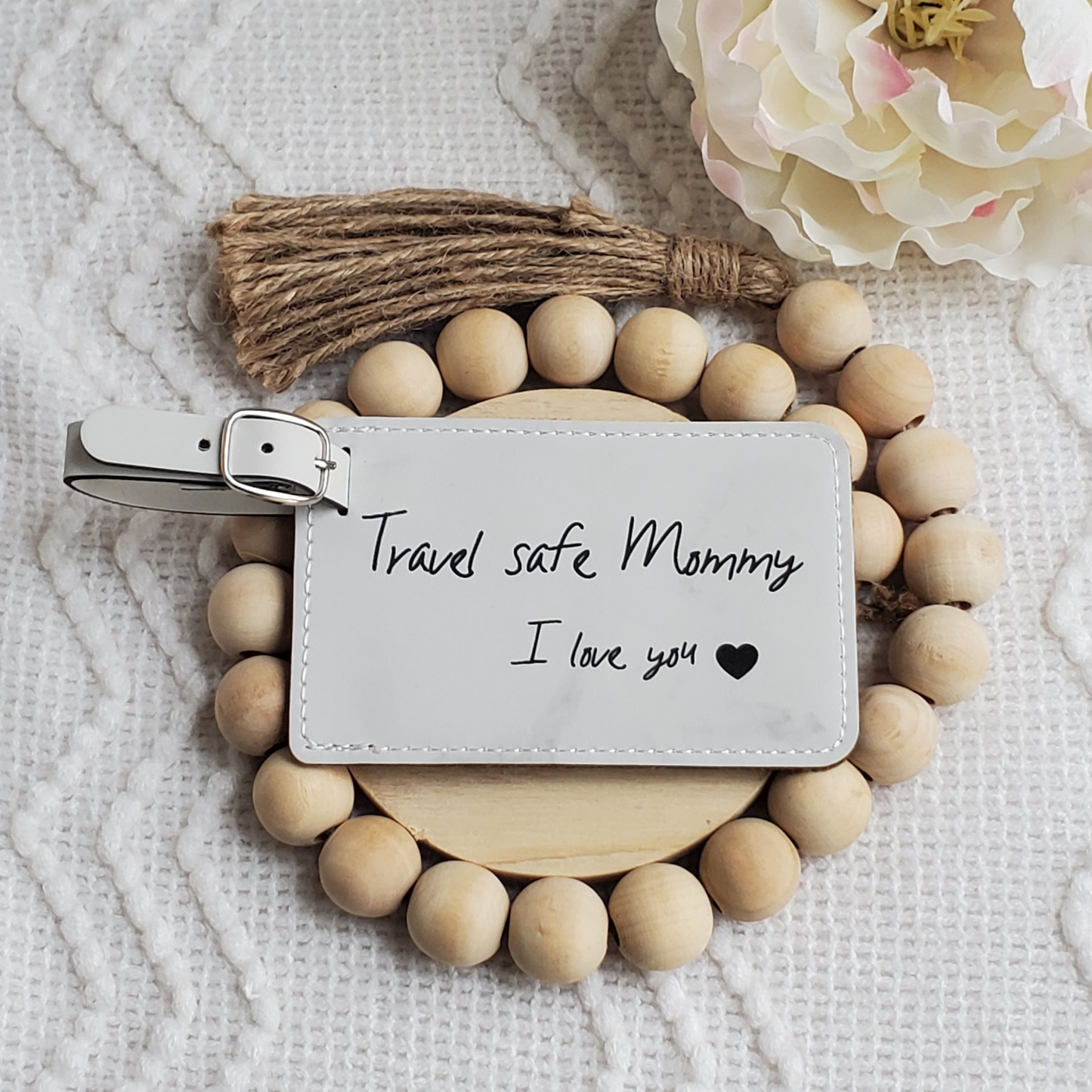 White luggage Tag with the words Travel safe Mommy I love you and a heart engraved in black.